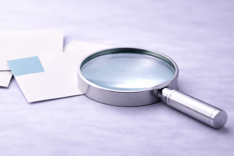 Vergrootglas op werktafel als symbool voor onderzoek en het vinden van passende oplossingen in inspiratiesessies op maat