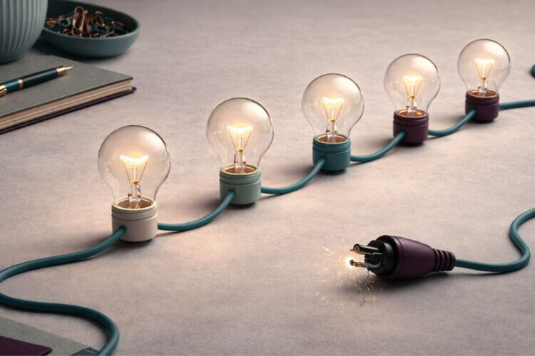 Brandende lampen op een tealkleurig snoer met een vonkende stekker als symbool voor energie zonder aansluiting bij verandertrajecten