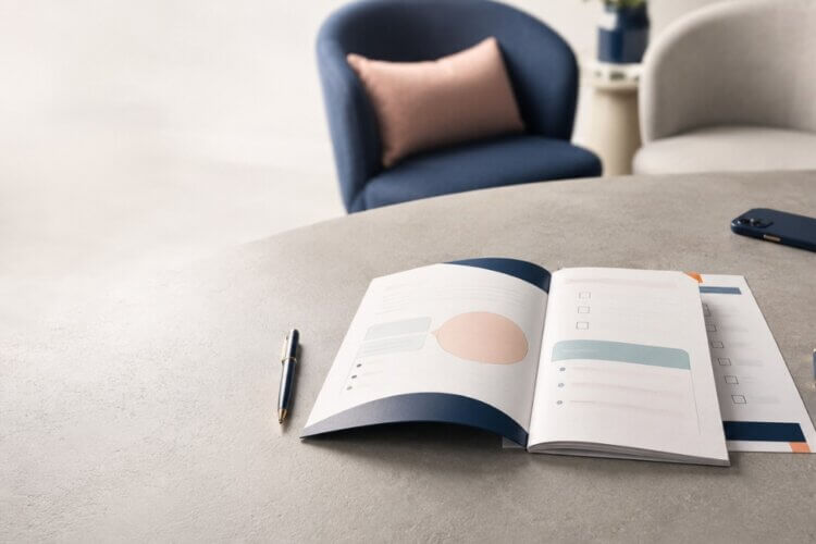Twee stoelen en een open gespreksformulier op tafel voor een functioneringsgesprek.